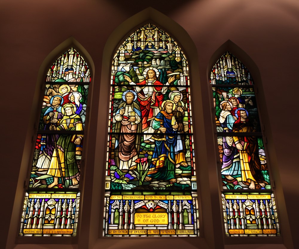 Three stained glass windows in a church sanctuary